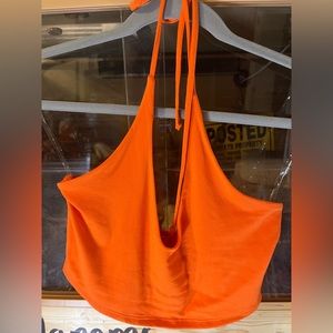 Orange backless haulter top. Stops just below the breast area. Spaghetti straps.